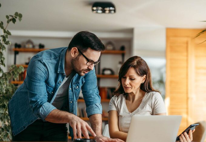 Couple at home discusses what a loan level price adjustment is while sitting at computer.