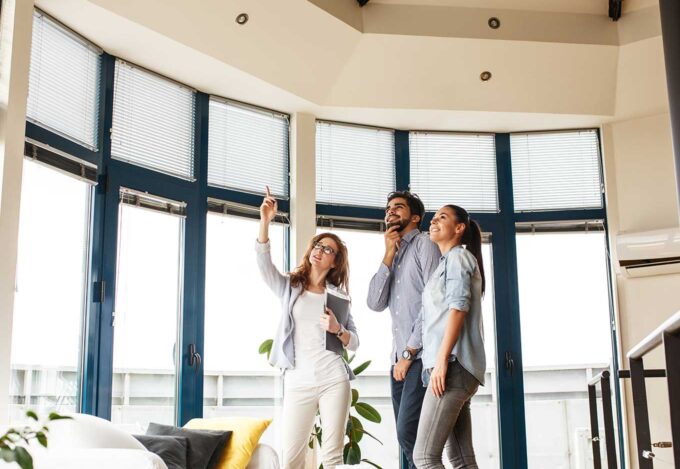 Couple tours a home during an open house with either a REALTOR® or a real estate agent.