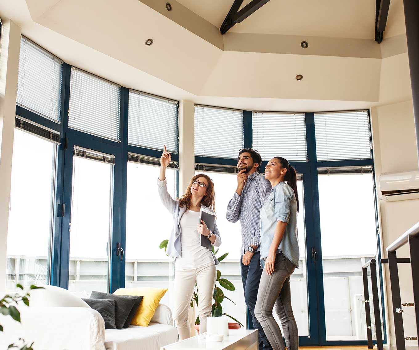 Couple tours a home during an open house with either a REALTOR® or a real estate agent.